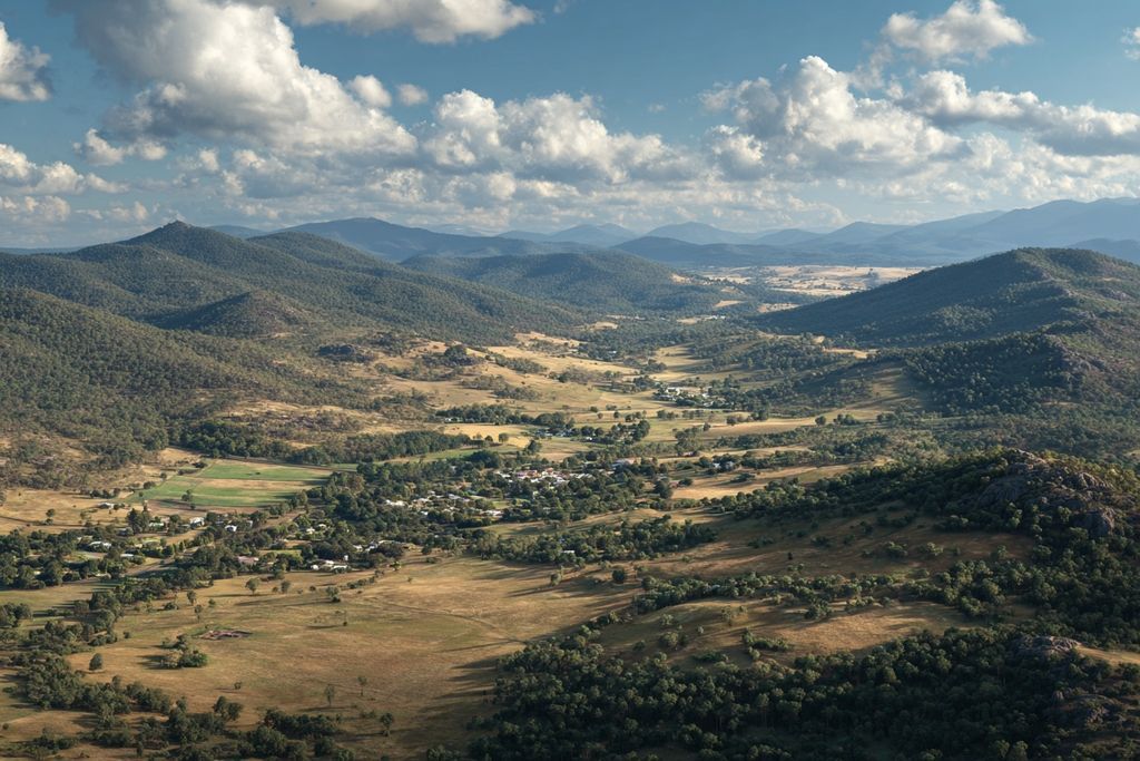 Un paysage paisible avec une harmonie entre les zones bâties et sauvages, symbolisant les opportunités de développement.